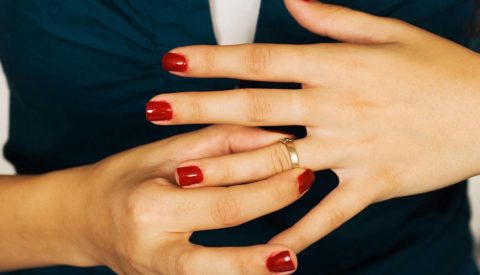 Женщина снимает кольцо с пальца.